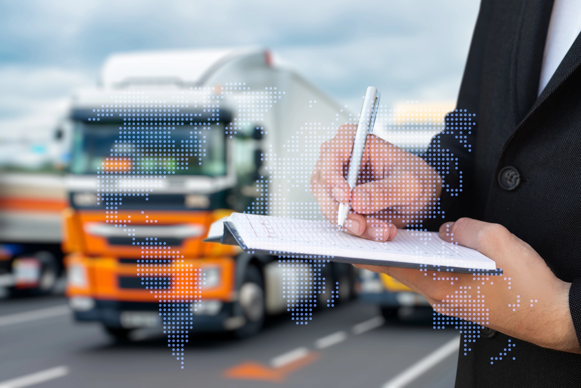 Unternehmer schreibt Notizen vor LKW-Flotte zu Tachographen-Pflichten