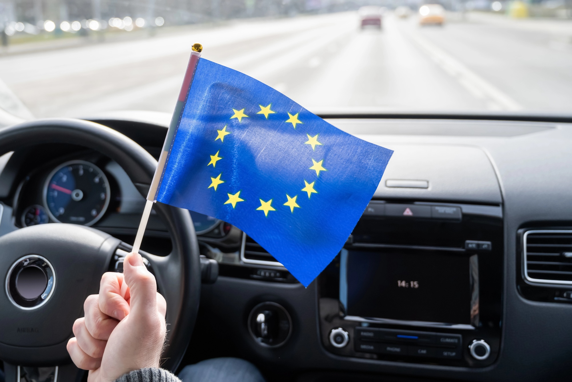 Fahrer hält EU-Flagge im Auto zur Tachographenpflicht in Europa